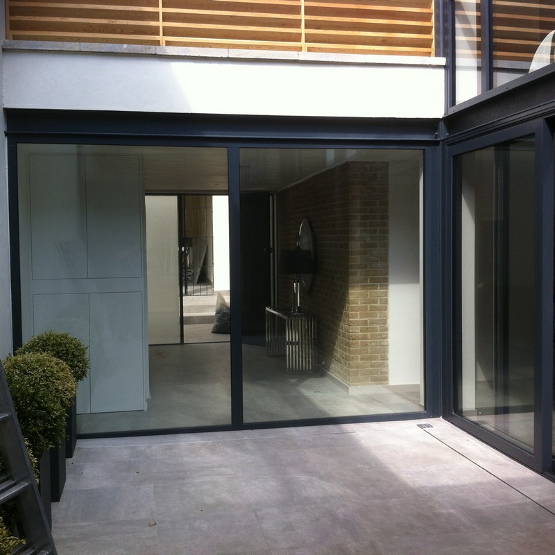 Floor-to-ceiling sliding doors opening to courtyard in Acton