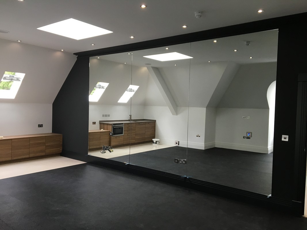 Frameless glass wall dividing loft conversion in Acton